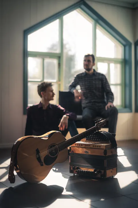 Press photo: Tim & Jonnic in a bright room with tall windows